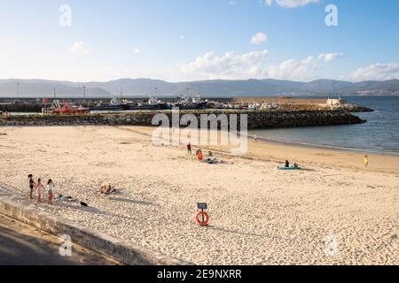 Europa, Spanien, Galizien, Porto do Son, Strand mit entferntem Hafen Stockfoto