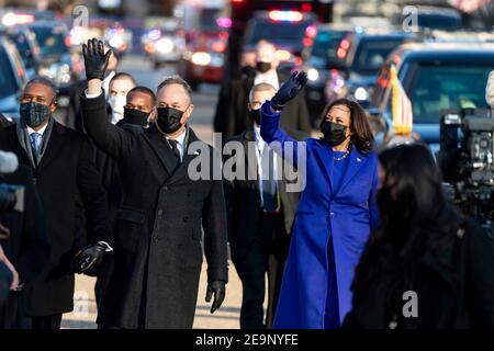 Die US-Vizepräsidentin Kamala Harris und der zweite Gentleman Doug Emhoff winken, während sie am 20. Januar 2021 in Washington, DC entlang der Pennsylvania Avenue gehen. Stockfoto