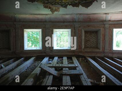 Wohnung von obdachlosen Mann im verlassenen Haus. Abblätternde Wände, Müll auf dem Boden, Fenster Stockfoto