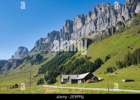 Bauernhaus mit den Bergen neben einer Passstraße in der schweiz an der Passstraße Klausenpass bei urnerboden, glarus Stockfoto