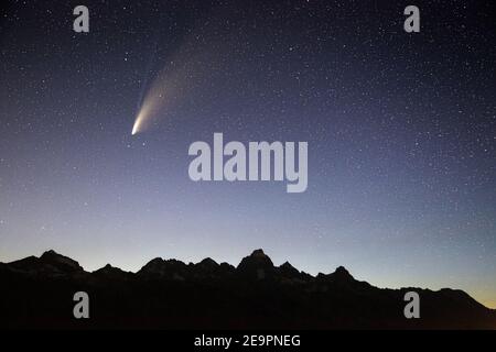 Komet Neowise streifend durch den Dämmerungshimmel über den Teton Mountains. Grand Teton National Park, Wyoming Stockfoto