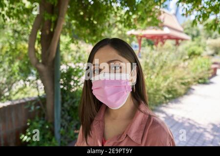 Eine schöne weiße Latina Frau Nahaufnahme trägt Gesichtsmaske Mitten im Cor Stockfoto