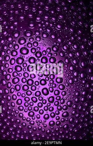 Blasen auf einem interessanten Hintergrund, chaotisch im Wasser auf der Glasoberfläche angeordnet Stockfoto
