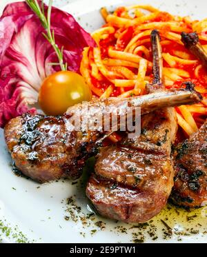 Gebratenes Lammkotelett mit Pasta und Salat Stockfoto