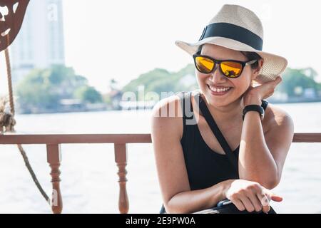 Frau, die eine Flusskreuzfahrt auf dem Chao Phraya Fluss in Bangkok macht Stockfoto