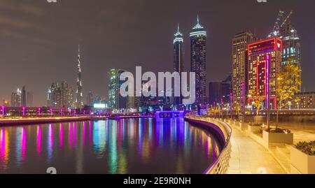 Dubai - die nächtliche Skyline über den Kanal und der Innenstadt mit dem Wasserfall auf der Brücke. Stockfoto