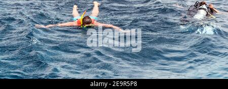 Zwei Tauchmänner nehmen an Tauchkursen Teil, die im wunderschönen blauen Ozean schnorcheln. Stockfoto