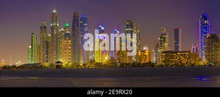 DUBAI, Vereinigte Arabische Emirate - 28. März 2017: Der Abend Skyline von Marina erhebt sich vom Strand entfernt. Stockfoto