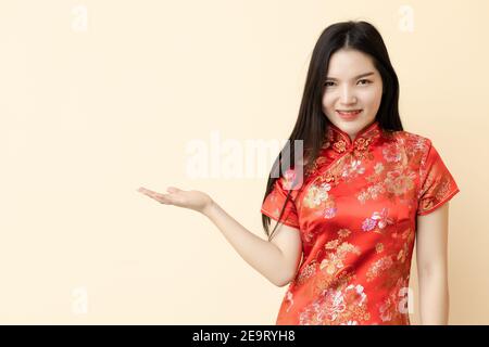 Chinesische Teenager-Mädchen in Gegenwart zeigen geben oder Verkauf Förderung Haltung Dressing Qipao traditionellen Tuch. Stockfoto