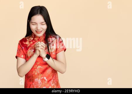 Chinesische Frauen kleiden Qipao traditionellen Tuch machen einen Wunsch oder beten in chinesischen Neujahrsfest mit Kopieplatz. Stockfoto