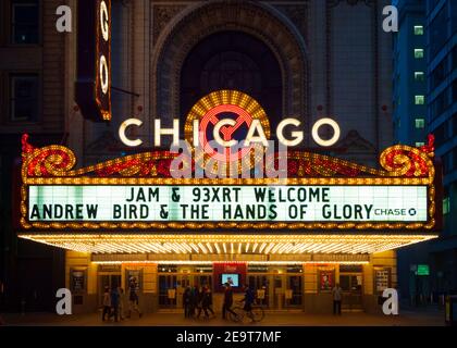 Das brillante, ikonische Festzelt des Chicago Theatre bei Nacht mit Menschen auf der North State Street in der Innenstadt von Chicago, Illinois. Stockfoto