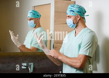 Der Arzt legt sterile medizinische Handschuhe an seine Hände, um sich vor einer Pandemie des Coronavirus covid 19 in Italien zu schützen. Hygiene für die Hände Stockfoto