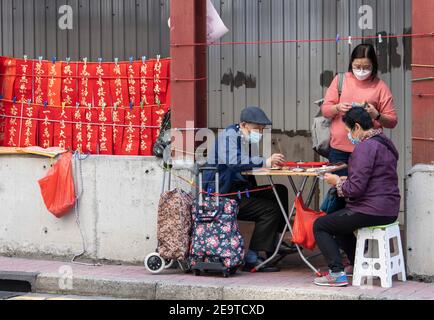 Hongkong, Hongkong, China. Februar 2021, 6th. Eine Kalligraphie sifu (Meister) arbeitet an der Seite einer belebten Straße in Causeway Bay Hongkong und produziert handbemalte kantonesische Couplets, die für das chinesische Neujahr bereit sind. Mondneujahrescouplets oder Cheun lyun, werden als Dekoration verwendet und haben unterschiedliche glückverheißende Nachrichten, die auf ihnen geschrieben werden. CNY wird am Freitag, 12th. Februar 2021 mit dem Feiertag beginnen, der das Tierkreisjahr des Ochsen ankündigt. Quelle: Jayne Russell/ZUMA Wire/Alamy Live News Stockfoto