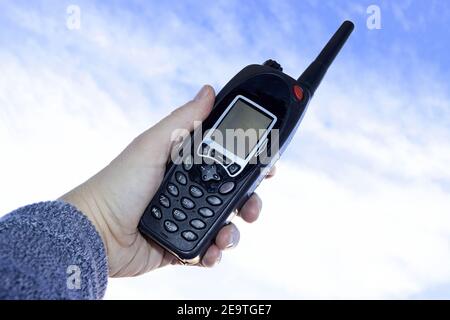 Mit einem Walkie-Talkie, Telekommunikationsgeräte gegen blauen Himmel Stockfoto