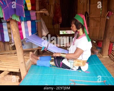 Long Neck oder Karen Hill Tribe Frau mit ihren Unterschrift Zubehör webt Tuch manuell. Einige der fertigen Stoffe wurden zum Verkauf ausgestellt Stockfoto