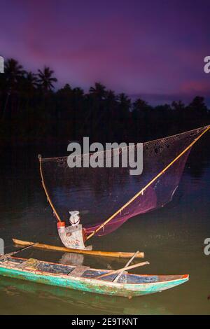 Ein einheimischer Fischer am Ubod River, der sein Netz in der Abenddämmerung auswirft, Donsol, Provinz Sorsogon, Luzon, Philippinen. Stockfoto