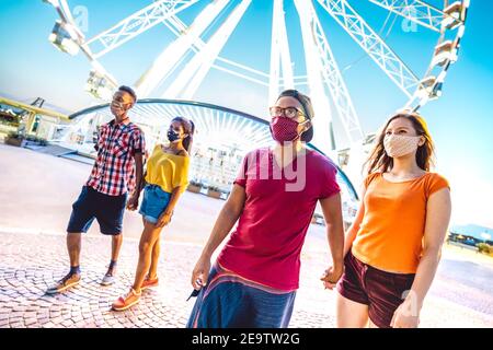 Multirassische Paare gehen mit Gesichtsmasken nach Lockdown Wiedereröffnung - Neue normale Lifestyle-Konzept mit Jungs und Mädchen Spaß haben Gemeinsam Stockfoto