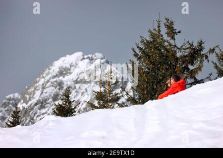 Garmisch Partenkirchen, Deutschland. Februar 2021, 06th. Ein Mann sitzt an der Kreuzung in der Sonne. Quelle: Karl-Josef Hildenbrand/dpa/Alamy Live News Stockfoto