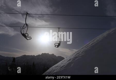 Garmisch Partenkirchen, Deutschland. Februar 2021, 06th. Die Gondeln eines Sessellifts hängen am Kreuzeck in der Sonne. Quelle: Karl-Josef Hildenbrand/dpa/Alamy Live News Stockfoto