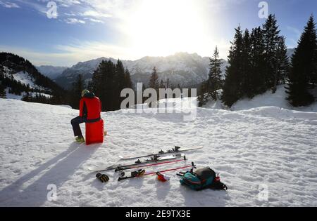 Garmisch Partenkirchen, Deutschland. Februar 2021, 06th. Ein Mann sitzt an der Kreuzung in der Sonne. Quelle: Karl-Josef Hildenbrand/dpa/Alamy Live News Stockfoto