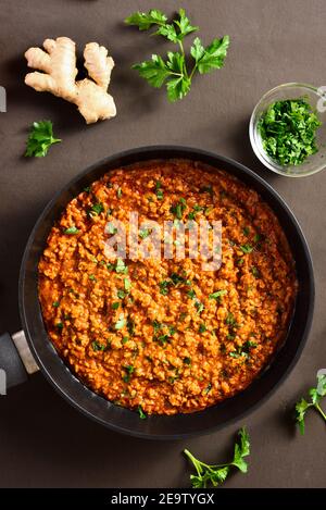 Keema Curry in Bratpfanne über dunklem Hintergrund. Indische und pakistanische Gerichte. Draufsicht, flach liegend, Nahaufnahme Stockfoto