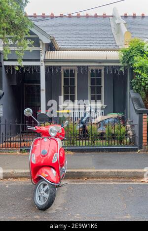 Eine kleine Doppelhaushälfte Federation Stil einstufige Terrasse Haus mit zwei Motorroller vor geparkt, in Newtown, New South Wales, Australien Stockfoto