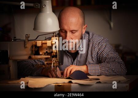 Mann arbeitet mit Nähmaschine tun hausgemachte Gesichtsmaske für Verhindern und verhindern der Verbreitung von Corona-Viren Stockfoto