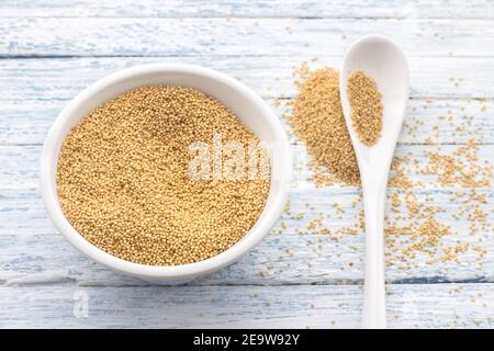 Rohe Amaranth-Samen in einer Keramikschale auf hellblauem Hintergrund, Draufsicht, selektiver Fokus Stockfoto