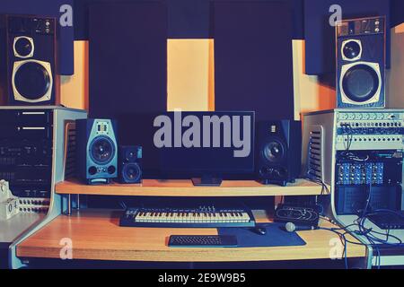 Computer, Lautsprecher und Audiogeräte auf dem Tisch im Aufnahmestudio Stockfoto