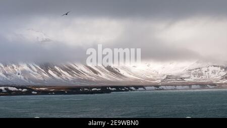 Verschneite Berglandschaft Wolkenlandschaft und Atlantischer Ozean auf Snaefellsnes Halbinsel Im Frühling in Island Stockfoto