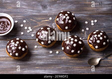 Würzige Kürbis-Muffins mit Nüssen, verziert mit Schokoladenglasur und Zucker Schneeflocken unter dem Weihnachtsbaum auf einem Holztisch, Freiraum, selektiv Stockfoto