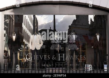 Im Fenster von Quality taylor Gieves & Hawkes in der Savile Row sind maßgefertigte Anzüge während der dritten Sperre der Coronavirus-Pandemie am 5th. Februar 2021 in London, England, zu sehen. Stockfoto