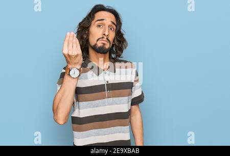 Junger hispanischer Mann in legerer Kleidung mit italienischer Geste mit Hand und Fingern selbstbewussten Ausdruck Stockfoto