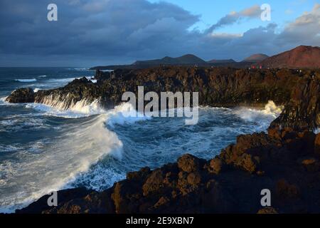Los Hervideros an der Westküste Lanzarotes in Abendsonne. Hohe Wellen kommen in. Kanarische Inseln, Spanien. Stockfoto
