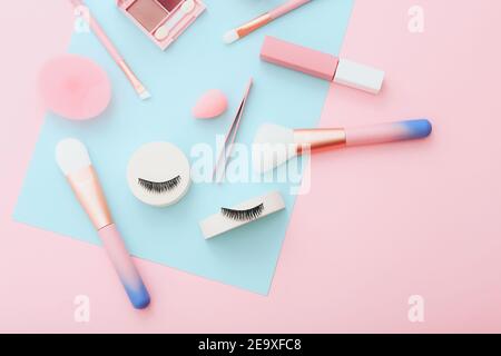 Make-up Werkzeuge und Zubehör auf blauem und pinkem Hintergrund. Schönheitskonzept. Flache Lay-Komposition, Draufsicht Stockfoto