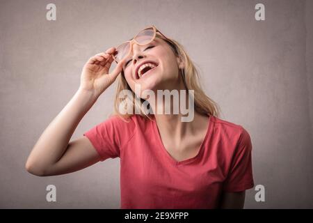 Porträt einer jungen fröhlichen blonden Frau mit Sonnenbrille tragen Ein rotes T-Shirt Stockfoto