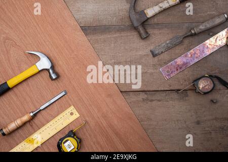 Hamer Meißel Maßband Lineal Sammlung von alten und neuen Holzbearbeitungshandwerkzeuge auf einer rauen Werkbank aus Holz Stockfoto