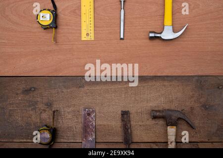 Hamer Meißel Maßband Lineal Sammlung von alten und neuen Holzbearbeitungshandwerkzeuge auf einer rauen Werkbank aus Holz Stockfoto