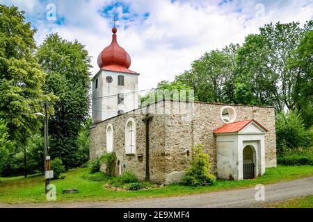 Vysoka, Tschechische Republik - Juli 6 2018: Blick auf die erhaltene Ruine der Kirche Johannes des Täufers aus dem 13th. Jahrhundert, weißer Turm mit Uhr. Stockfoto