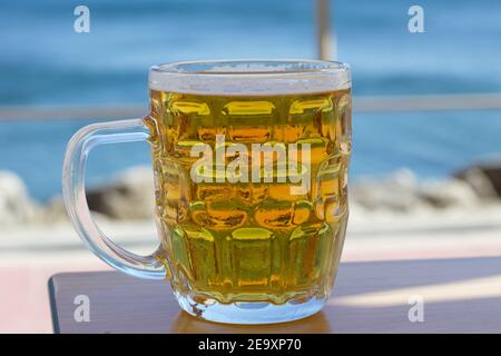 Ein Glas Bier vor dem Atlantik Stockfoto