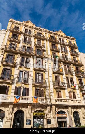 BARCELONA, SPANIEN, 3. FEBRUAR 2021: Typische Fassade eines modernistischen Barcelona-Gebäudes. Auf einigen Balkonen können wir katalanische Unabhängigkeitsflaggen sehen. Stockfoto