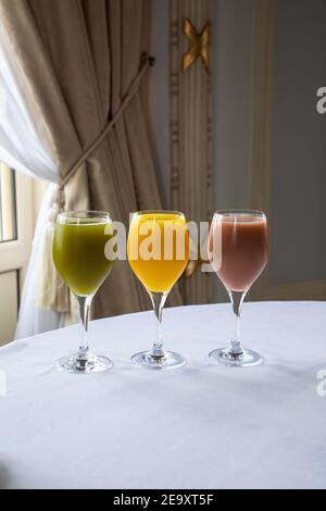 Verschiedene bunte frisch gepresste Säfte in eleganten Gläsern platziert auf Tisch im Restaurant Stockfoto