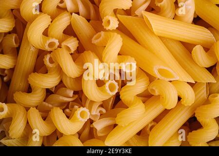 Textur der Vielfalt ungekocht goldenen Weizen Pasta Hintergrund, Draufsicht Makro Stockfoto