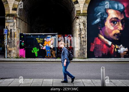 Straßenszene von Graffiti in Abbots Road, Gateshead, mit einem Mann, der 2016 vorbeiging Stockfoto