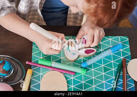 Nahaufnahme des Jungen Malerei Kaninchenfigur am Tisch und Vorbereitung auf Ostern Stockfoto