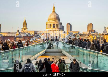 Menschenmassen überqueren die London Millennium Footbridge mit Saint Pauls Kathedrale im Hintergrund Stockfoto