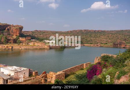 Badami, Karnataka, Indien - 7. November 2013: Höhlentempel über dem Agasthya See in NE-Ansicht, umgeben von Hügeln, Felsen und Klippen unter blauer Wolkenlandschaft Stockfoto