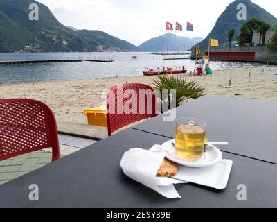 Lugano, Schweiz - 21. Mai 2018: Tasse Tee auf Couchtisch mit Seeblick Stockfoto