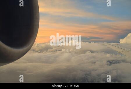 Blick auf den Himmel, Wolken, Flügel und Motor aus einem Flugzeugfenster. Stockfoto