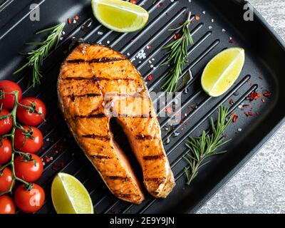 Gegrillter Steak Fisch Lachs, Forelle in einer Grillpfanne, Gewürze, Tomaten, Nahaufnahme Stockfoto